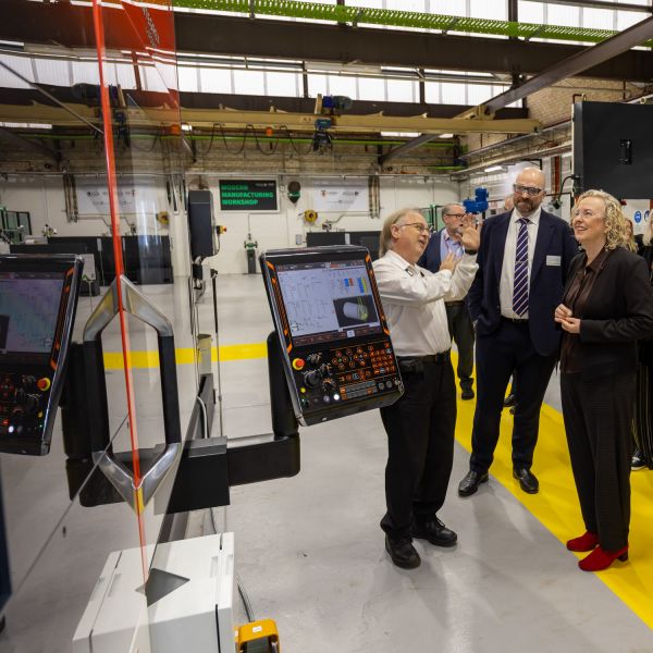 technical equipment on display, observed by a group of three