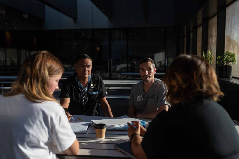 Four medical professionals sit around a table 