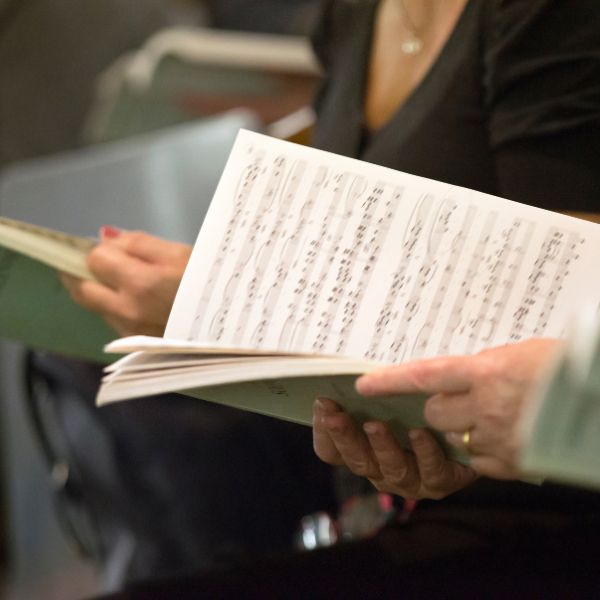 choir members holding sheet music