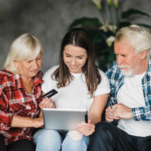 A young woman sits between her mother and father with credit card in hand