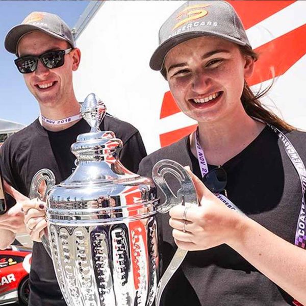 two students holding a trophy. Supercars Giveaway
