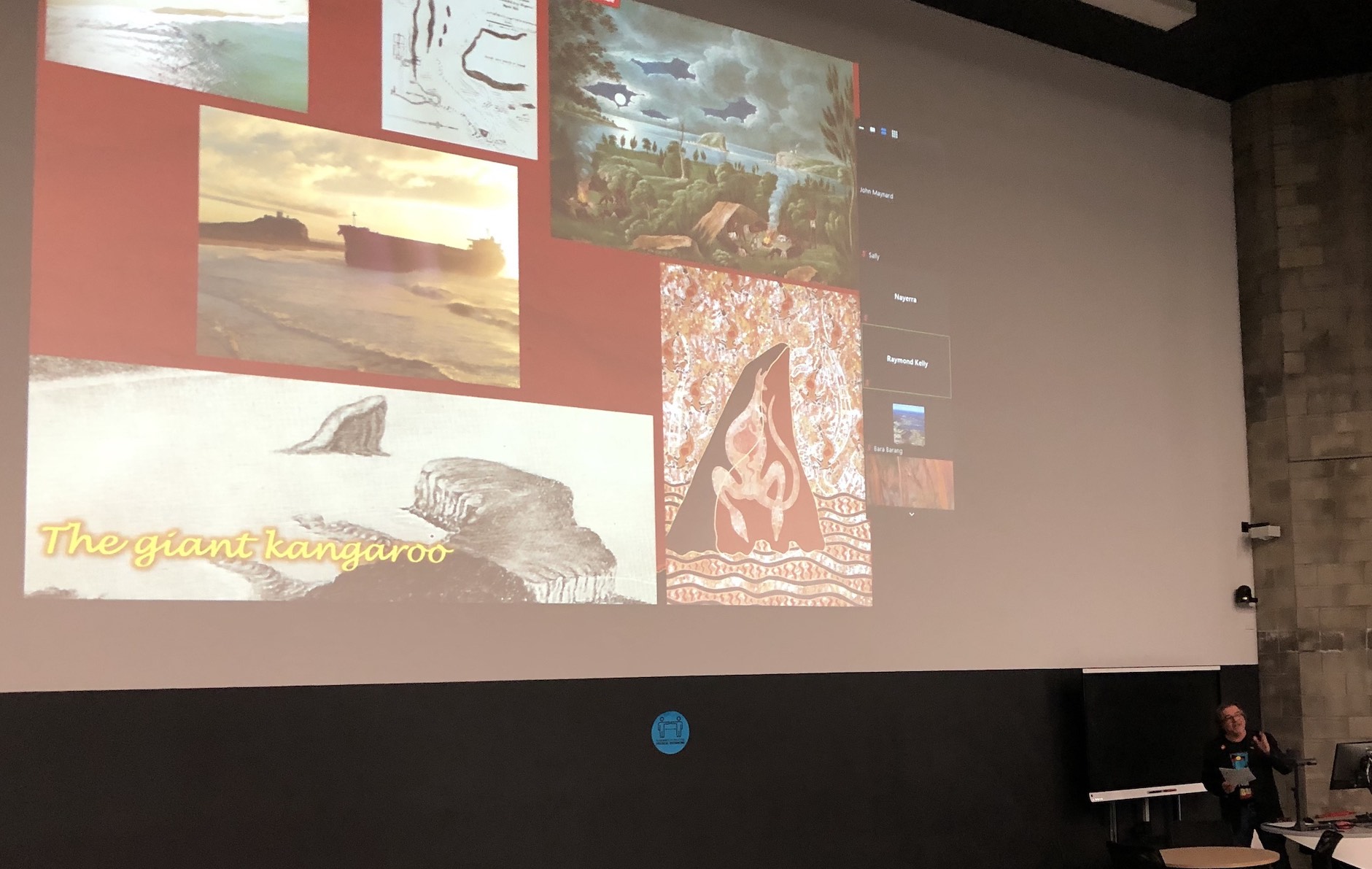 2020 NAIDOC Week lecture: Professor John Maynard Lecture theatre with project slides showing depictions of 1880s Newcastle. Professor John Maynard is speaking.