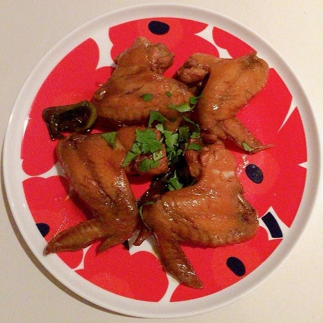 Photo of cooked chicken wings on a red plate