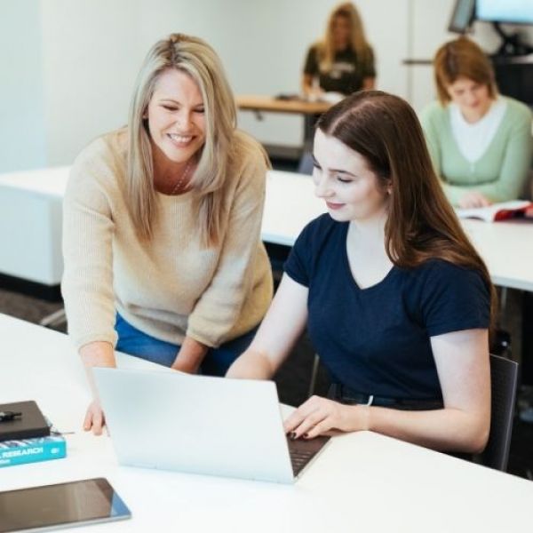 Tutor helps student with class work. The University of Newcastle introduces new pathway to uni