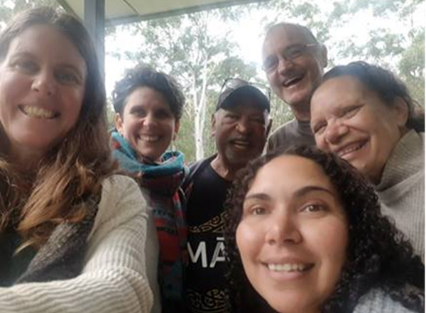 A group of six people (4 women & 2 men) smiling