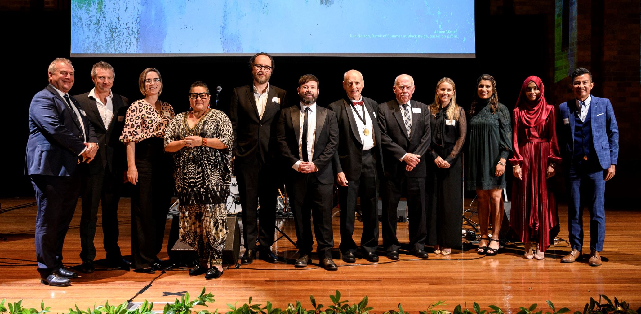 Awards winners standing on stage with Chancellor and Vice-Chancellor