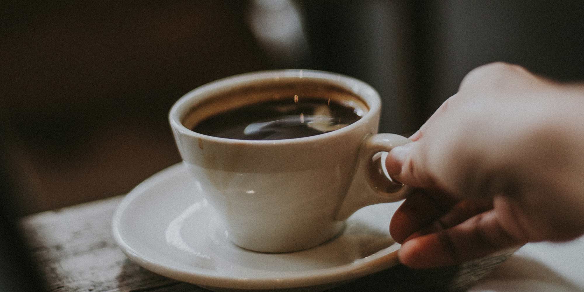 A hand holding a coffee mug