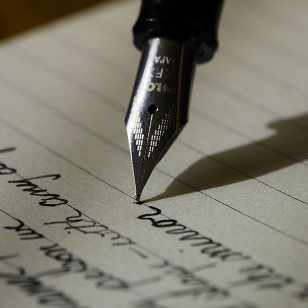 Pen writing in notebook