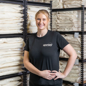 A person standing in front of a stack of woodDescription automatically generated with low confidence