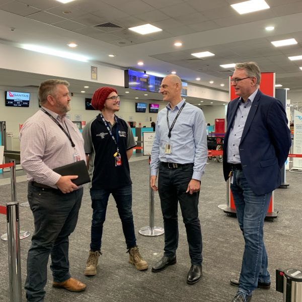 Four men standing and talking at Newcastle Airport. Innovative ‘Living Laboratory’ sees students solve real problems at Newcastle Airport 