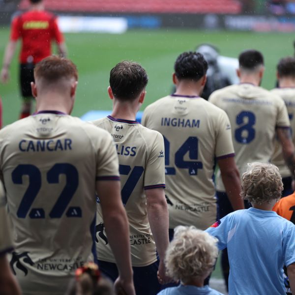 Jets Mens team walking onto field with young boys