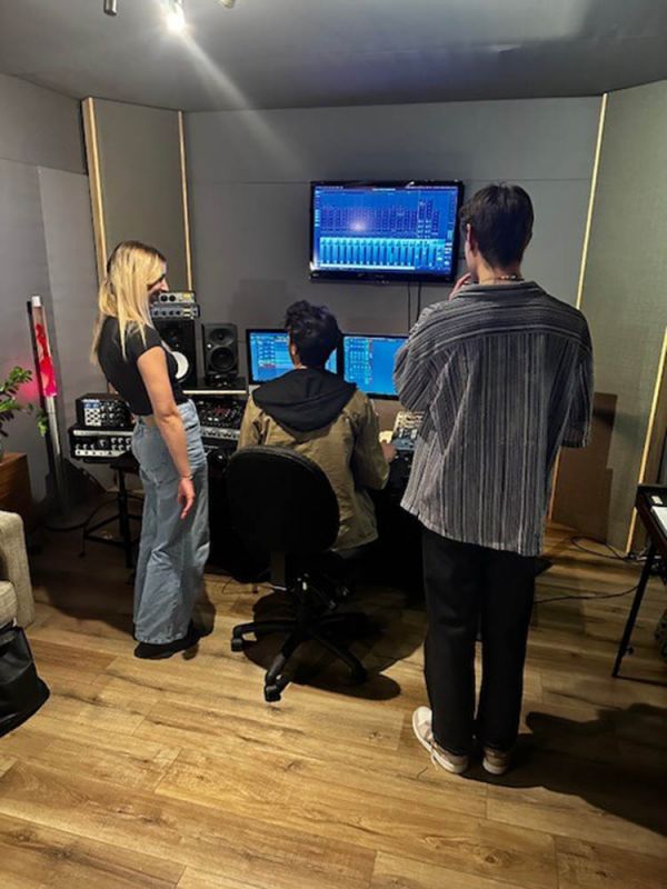 Three people in a recording studio creating an advertisement