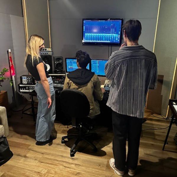 Three people in a recording studio creating an advertisement
