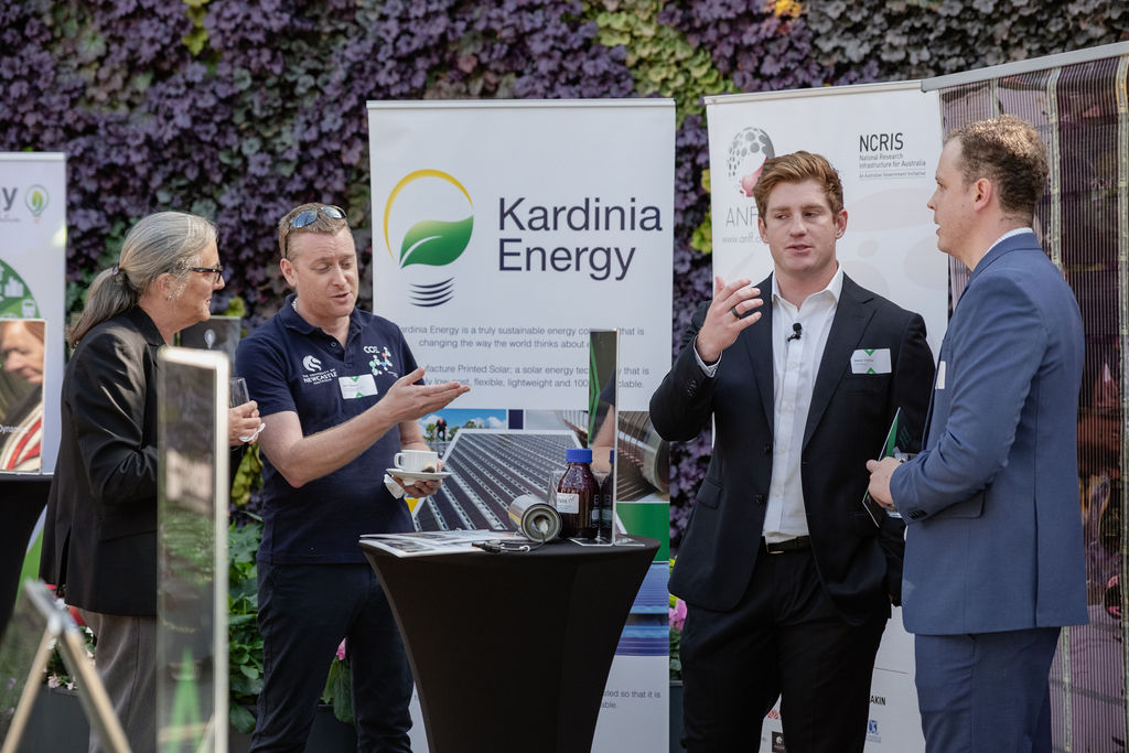 Staff from Kardinia Energy networking at the showcase next to a demonstration of their printed solar.
