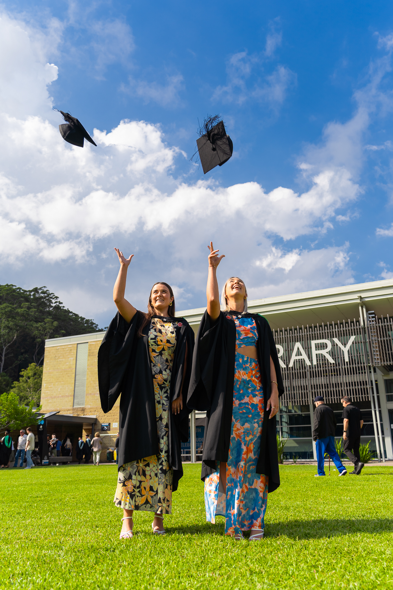 Two graduates throw their caps in the air