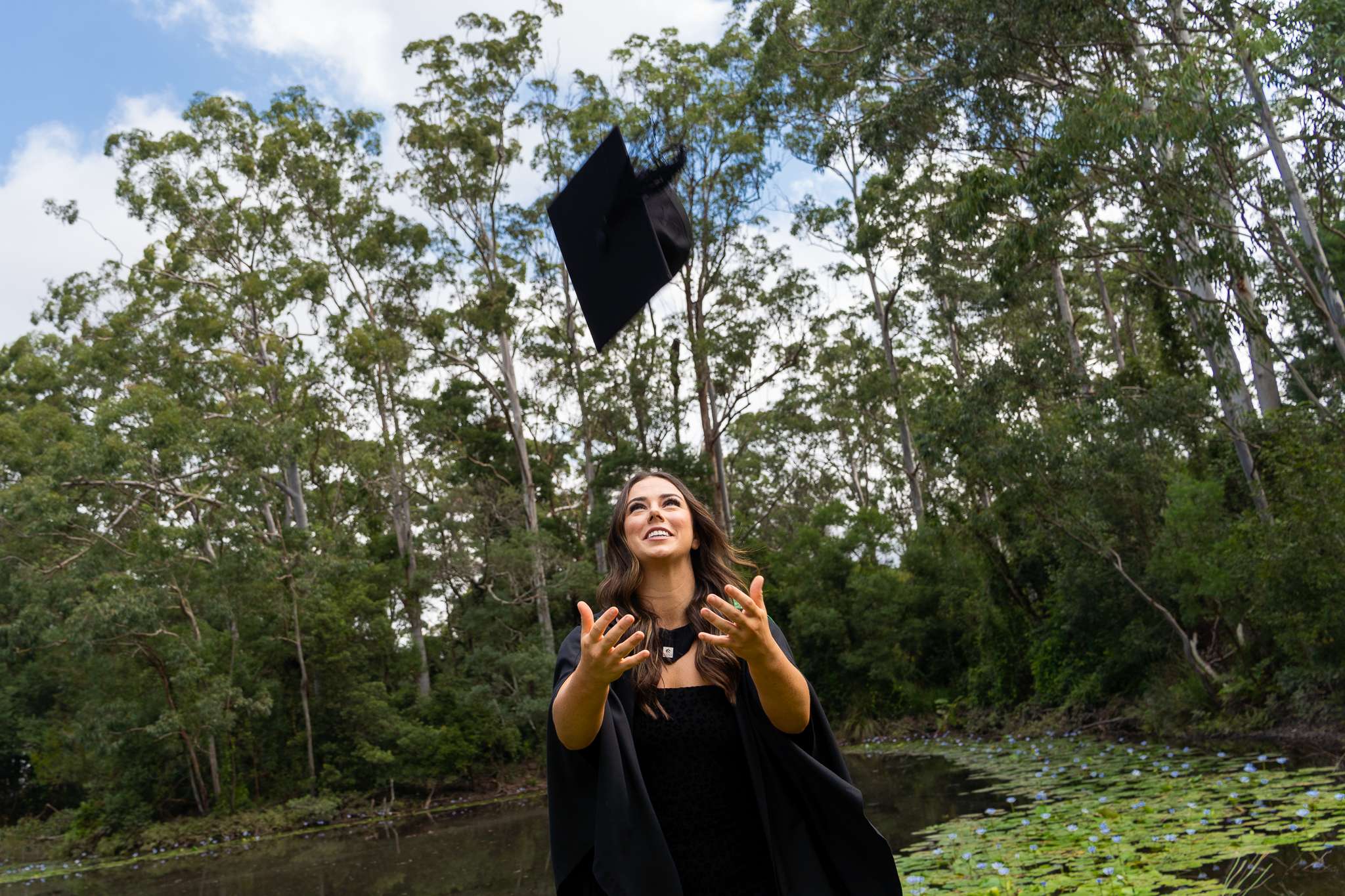 Graduate has hands out to catch her cap