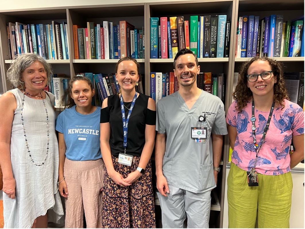 Five individuals standing and smiling