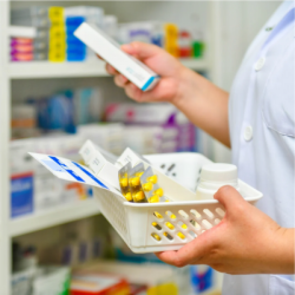 Pharmacy event image image of pharmacy, person holding tablets with shelving behind