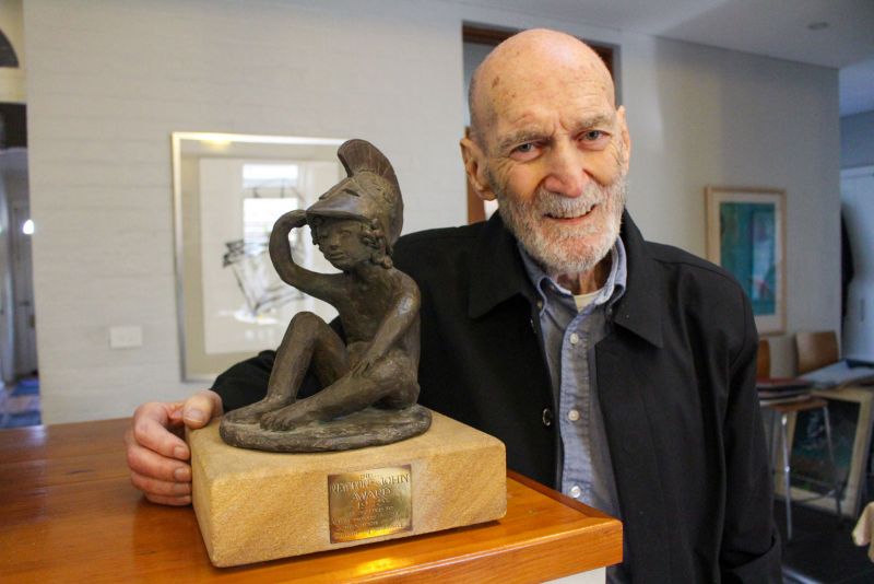 Allan stands next to his Newton-John Alumni Award Trophy.
