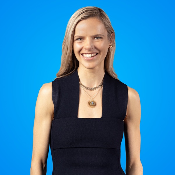 Woman smiling for the camera in front of a blue background