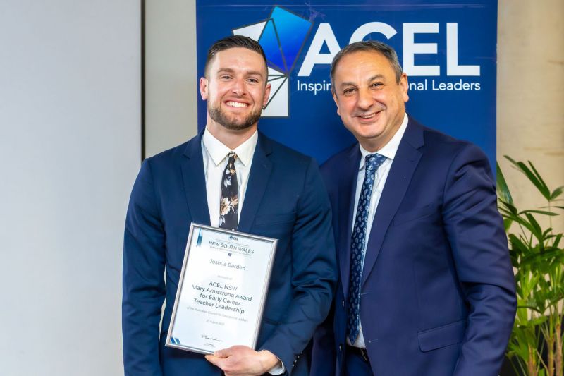 Josh is standing with another male, smiling and posing with an award certificate at the ACEL NSW Branch awards.