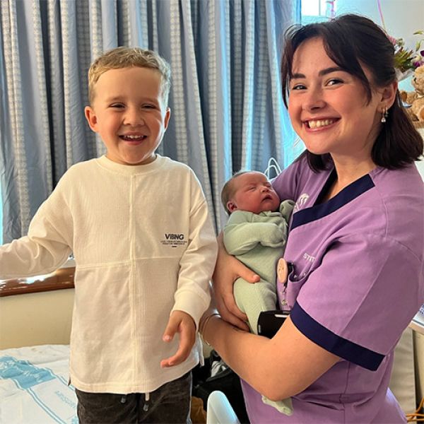 Jessie working in midwifery ward holding newborn baby