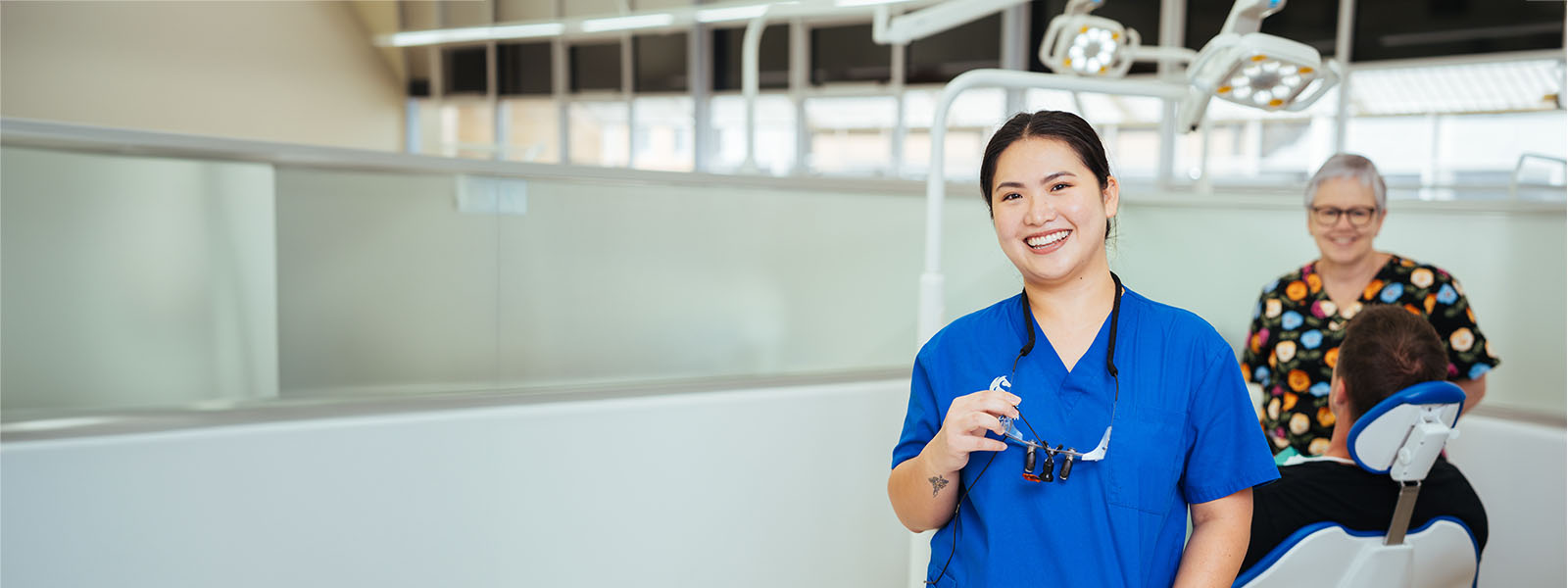 A female doctor standing in a lab in front of patients