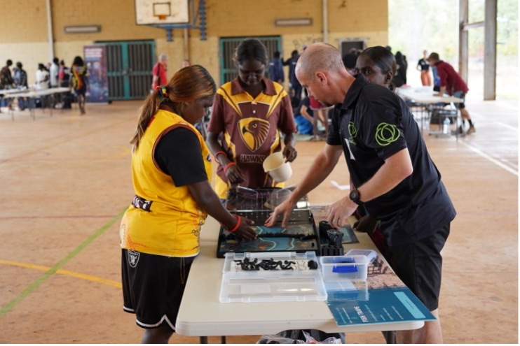 University staff showing students how to do the fish trap challenge
