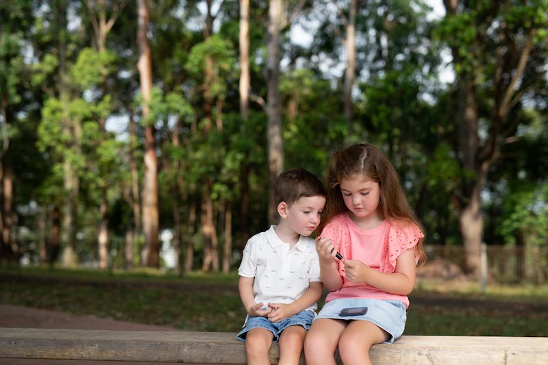 Gabrielle undertakes finger prick test while her younger brother looks on