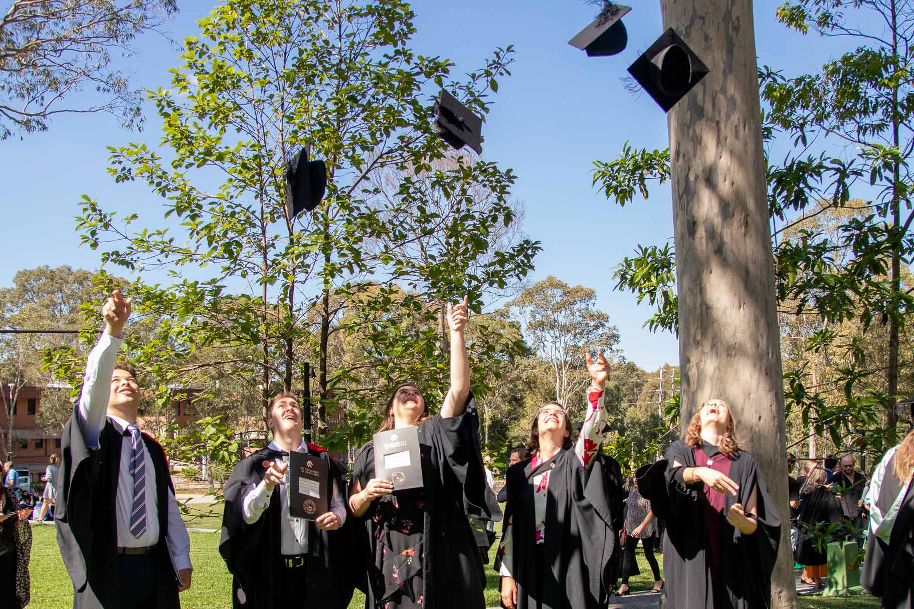 Graduates throw hat in air