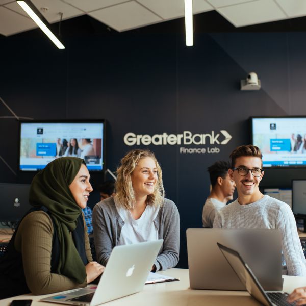 Three students working in the Greater Bank Finance Lab . Hunter Ambassadors fostering greater Financial Literacy