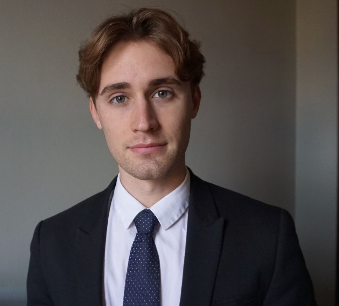 Levi is pictured in a black suit jacket and tie 