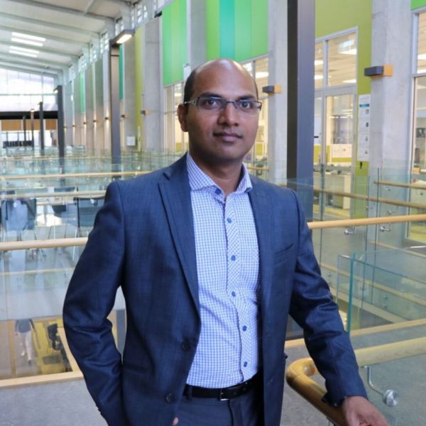 Professor Vinu stands looking at the camera