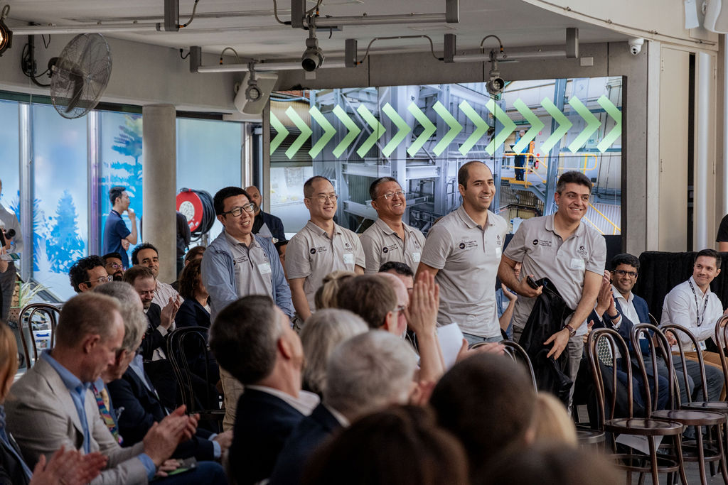 Some of the members of L/Prof Moghtaderi's Centre for Innovative Energy Technologies team standing for applause at the showcase.