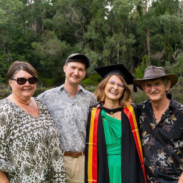 Graduate laughing with family. Shanae’s passion for caring delivers her dream to work in health 