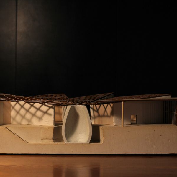 Architectural model with a modern design, featuring a latticed roof and smooth, curved walls. Set against a dark background.