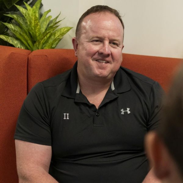 Grant sitting in at an indoor bench seat and smiling
