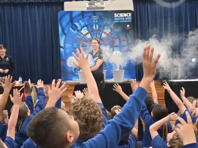 SMART staff member pushes fog through an air canon towards primary school students 