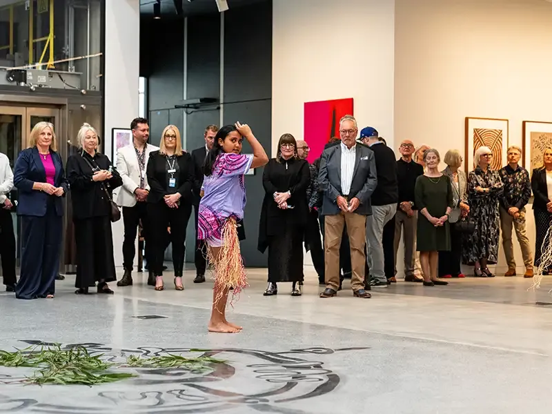 A crowd of onlookers watching a performance at Newcastle Art Gallery