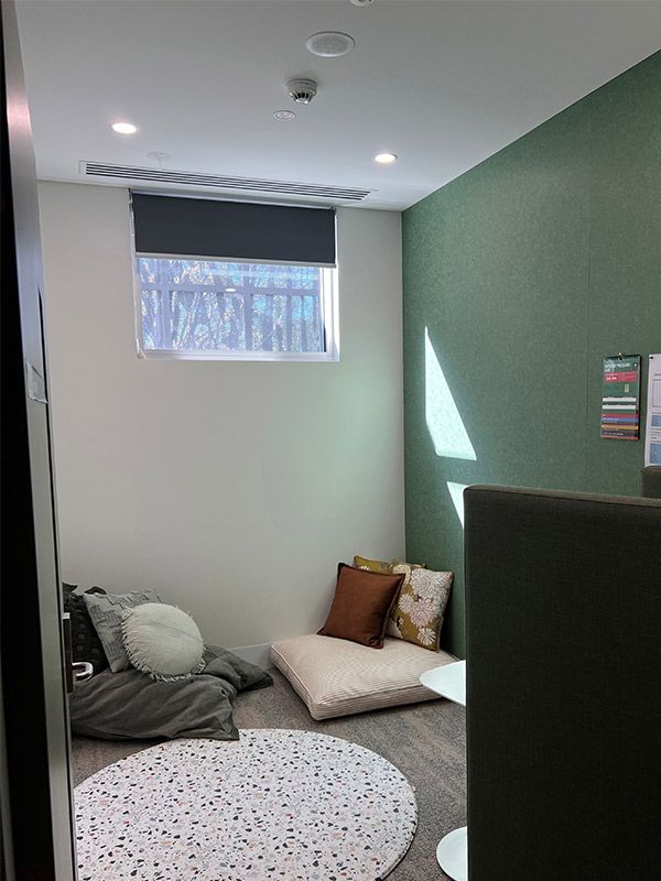 A small room with two bean bags in the corner. A circle white spotted rug is on the ground.