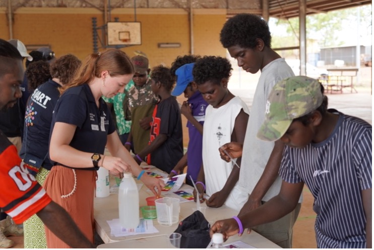 University staff with students performing STEM activity