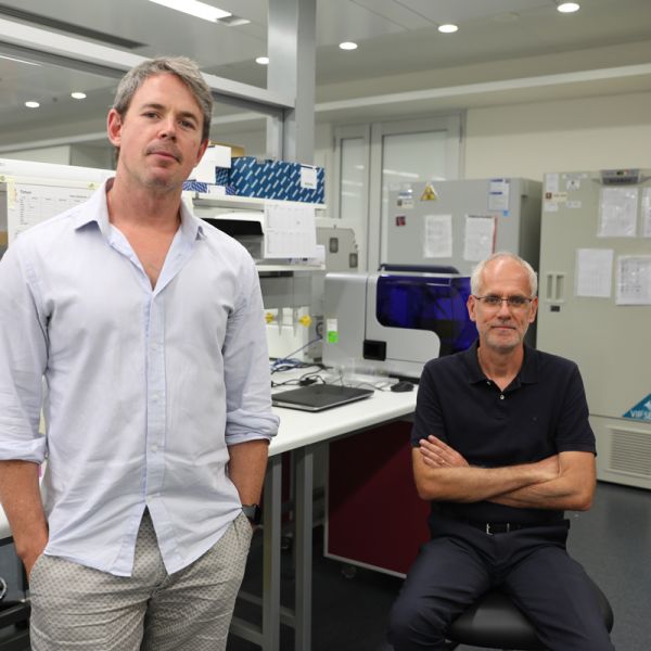 Nathan Barlett and Hubert Hondermarck in a labratory looking at the camera. Drug repurposing potential for COVID-19