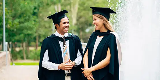 Two graduates smiling after graduating