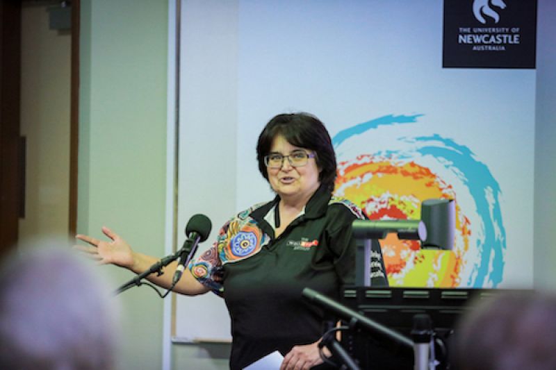 Woman in lecture theatre introducing guest presenter