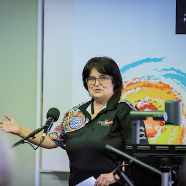 Woman in lecture theatre introducing guest presenter