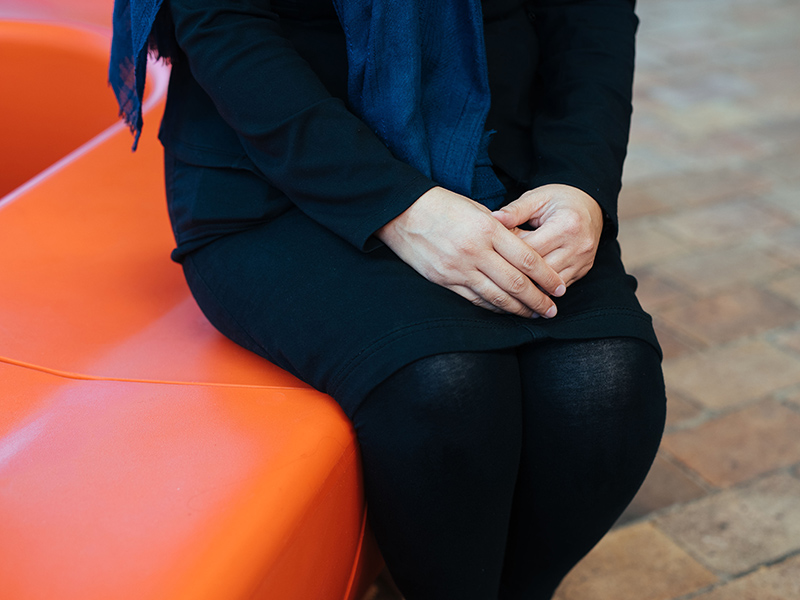 Laila sits with hands in her lap