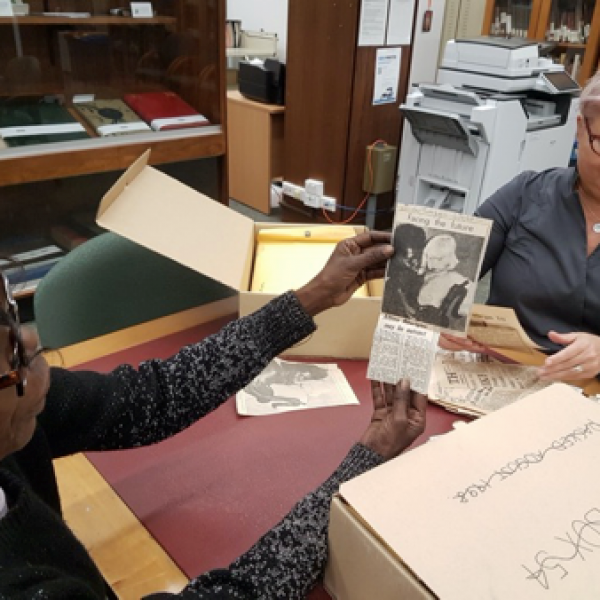 A woman sitting at a table looking at a newspaper cutting. From Ngukurr to Newcastle: Exploring the activism, impacts and legacy of Dexter Daniels 