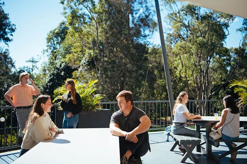 Residents relaxing on the Edwards Hall Dining Hall verandah