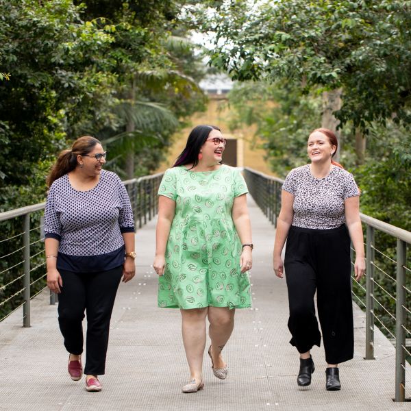Three women walk towards the camera laughing