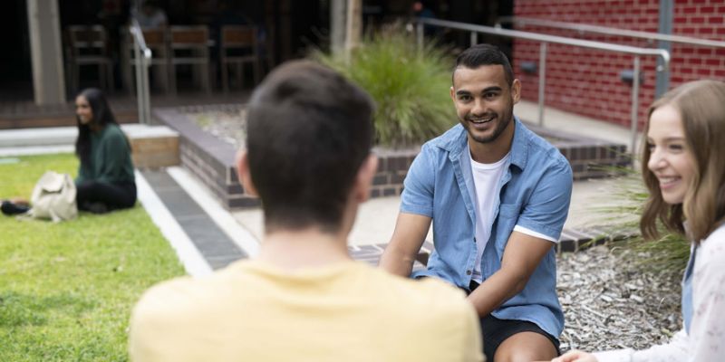 Three students sitting around talking 
